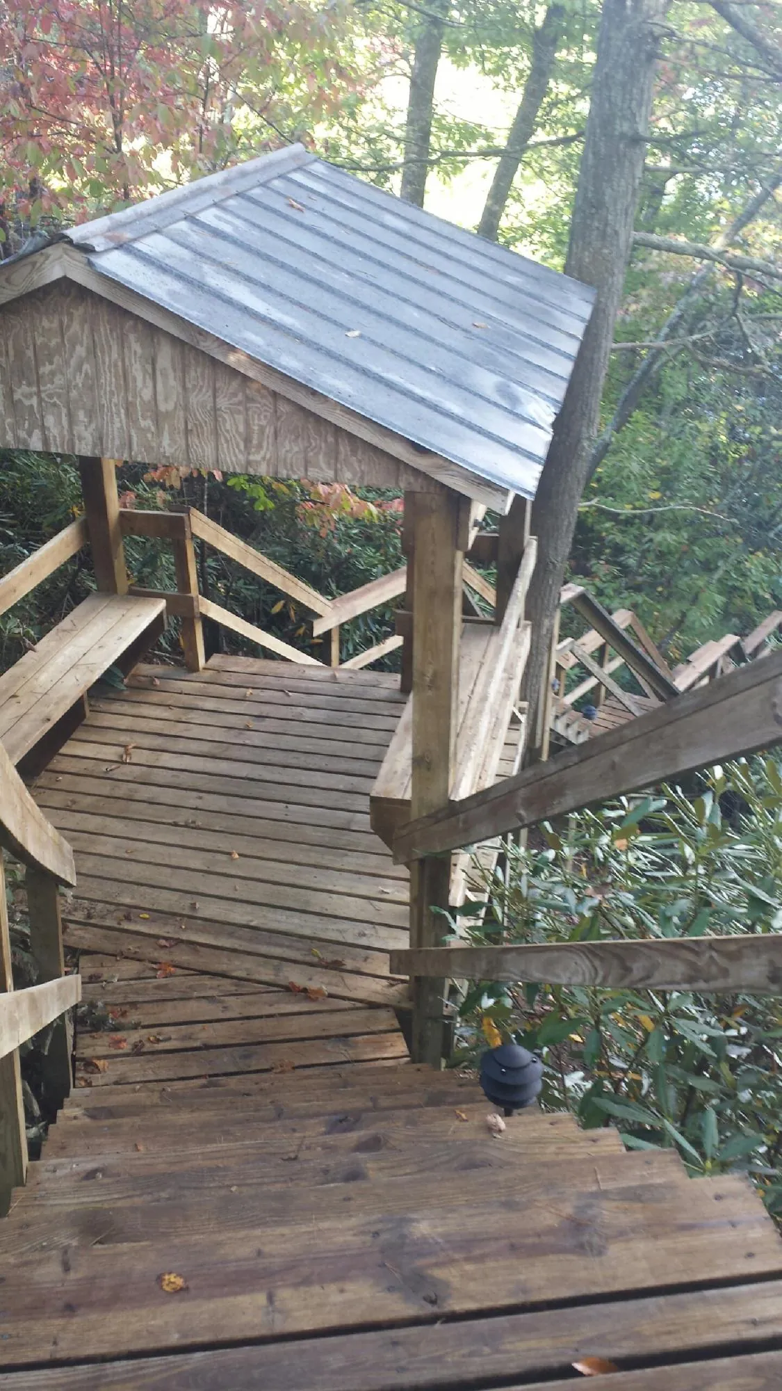Metal roofed shelter over wooden steps on a wooded walkway — Skylight Repair & Installation work by our crew in Shady Side