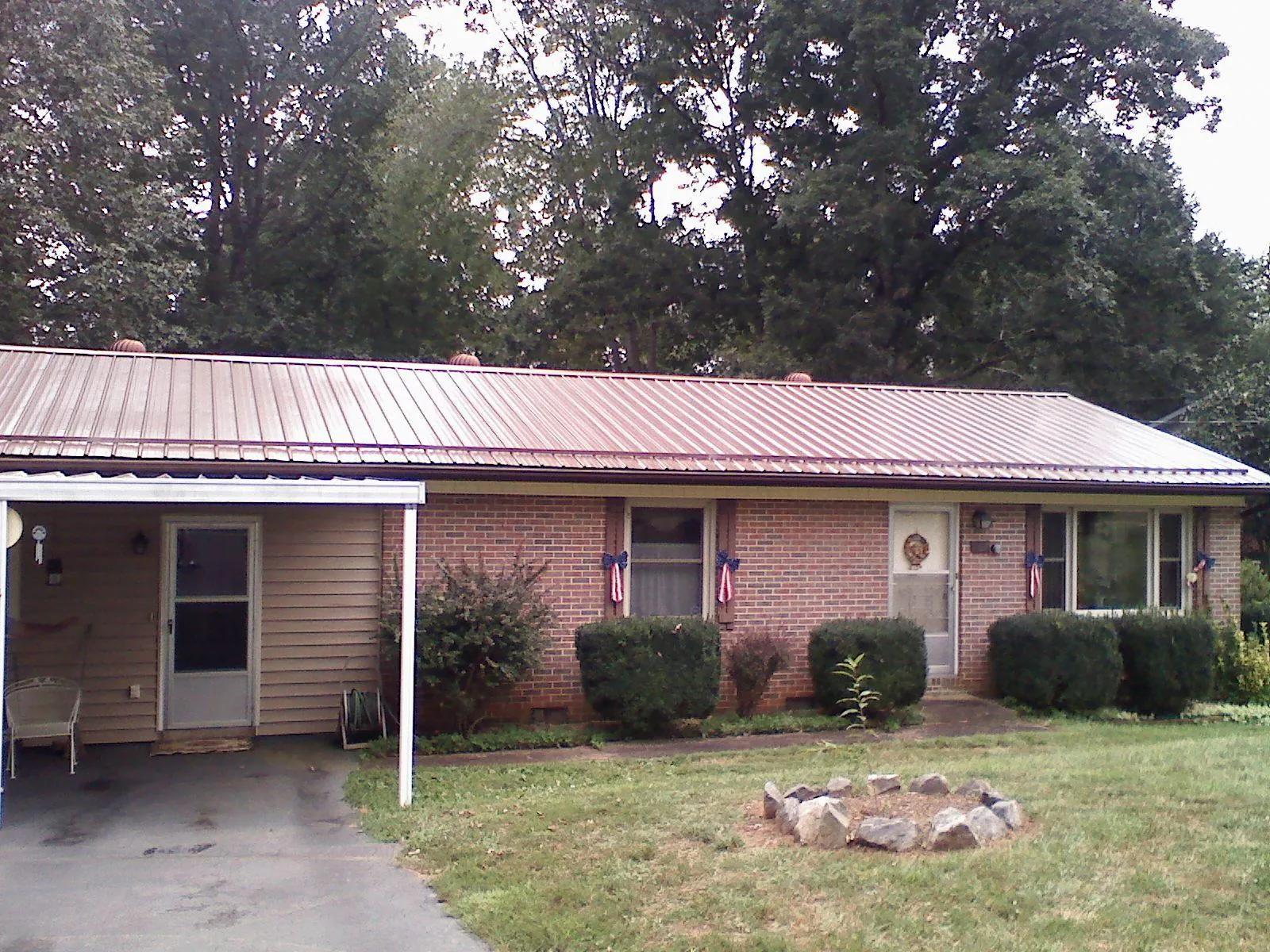 Bronze metal roof and carport on a brick ranch home — Roof Repair work by our crew in Shady Side